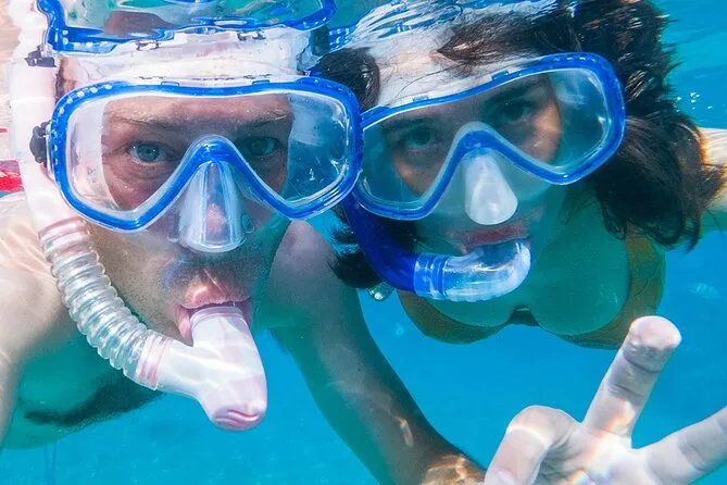Crystal-clear turquoise water at Norman Island BVI with snorkelers near the entrance to the famous sea caves — the premier snorkeling spot in Tortola and the British Virgin Islands