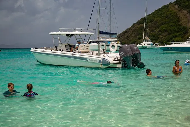 Private BVI snorkel charter anchored in calm turquoise water between islands on a Tortola snorkeling day — clear blue sea and tropical coastline of the British Virgin Islands